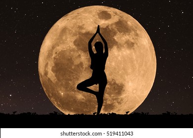 Silhouette Young Woman With Good Shape Practicing Yoga Under Full Moon At Night With Stars