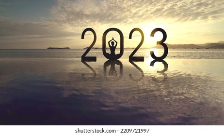 Silhouette of young woman meditating with 2023 numbers on the beach at sunset time with dawn sunlight background - Shutterstock ID 2209721997