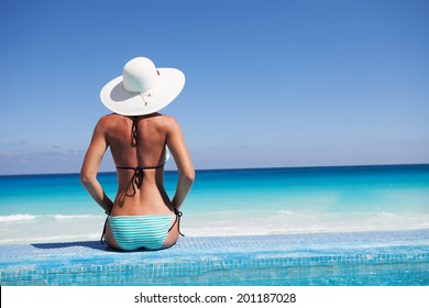 Silhouette Of Young Woman On Beach With Hat