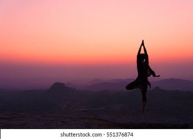 Silhouette Young Woman Practicing Yoga On The Hill At Dawn. Hampi, India