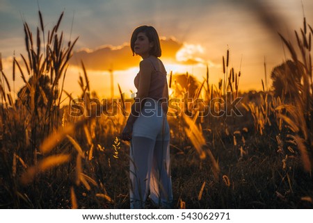 Similar – Beautiful young photographer woman wearing black clothes, sitting on the floor in countryside with her camera