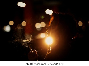 Silhouette of young woman smoking cigarette - Powered by Shutterstock - Get 15% off with code: PIKWIZARD15