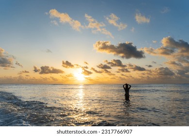 silhouette young woman standing in ocean during sunrise with han - Shutterstock ID 2317766907
