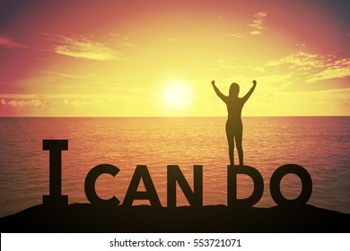 Silhouette young woman standing and raising up hand about winner concept at I CAN DO text over a beautiful sunset or sunrise at the sea. background for success in 2017 years .hope to business success