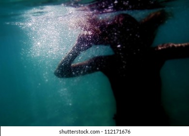 silhouette of young woman underwater