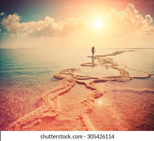 Silhouette of young woman walking on Dead Sea at sunrise. Solitude - Powered by Shutterstock