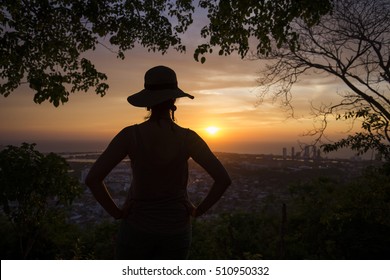 Silhouette of a young woman watching the sunset over Cartagena de Indias