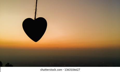 Silhouette,A heart-shaped silhouette representing the meaning of love, compassion and friendship that has been given to friends and his lover on the background of the golden sky in a beautiful morning