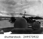 Silhouetted by helmets, view shows two landing craft at Omaha beach on D-Day. Each large ship landed 200 soldiers. June 6, 1944, World War 2.