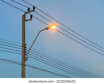 Silhouetted electricity transmission power lines and towers standing against a scenic sky at dusk or dawn. - Powered by Shutterstock