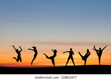 Silhouetted Group Tumbling And Dancing In Sunset 