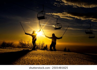 Silhouetted skiers celebrating at sunset on a snowy mountain. Stunning scenery with ski lift and golden sky. - Powered by Shutterstock