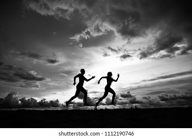 silhouettes of athletes running along the beach / sports summer in the warm sea, healthy rest, sports activity, summer vacation - Powered by Shutterstock