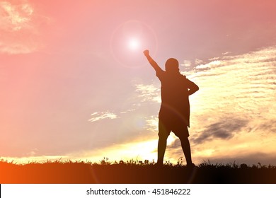 silhouettes of a boy stand and hand up at the sky sunset. Concept big dream and success