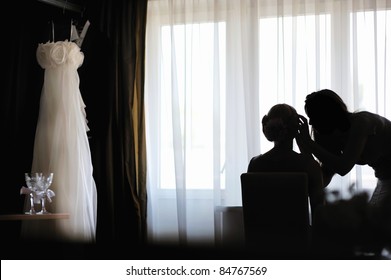 Silhouettes of a bride applying make-up and a make-up artist - Powered by Shutterstock