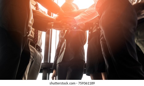 Silhouettes Business People Join Hand Stack Hand Together During Their Meeting With Sun Rays Aura Background.