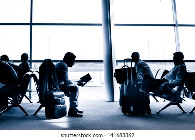 Silhouettes Of Business People Traveling On Airport; Waiting At The Plane Boarding Gates.