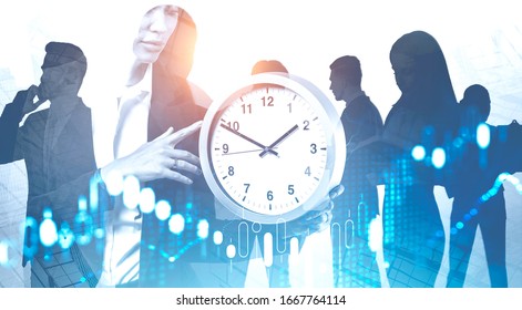 Silhouettes of business people working in abstract blurry city with double exposure of woman holding big clock and digital graph. Concept of time management and investment. Toned image - Shutterstock ID 1667764114