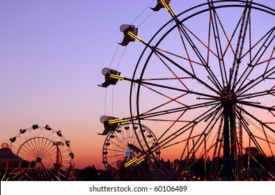 Silhouettes of carnival rides under sunset