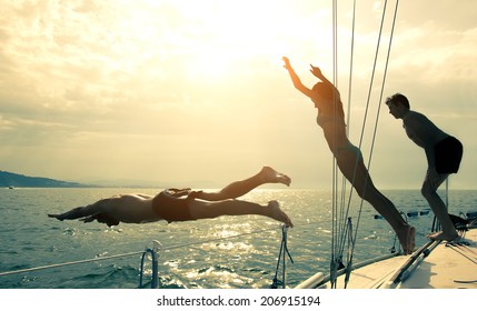 Silhouettes of children diving from the bow of a boat - Powered by Shutterstock