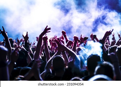 silhouettes of concert crowd in front of bright stage lights - Shutterstock ID 231094354