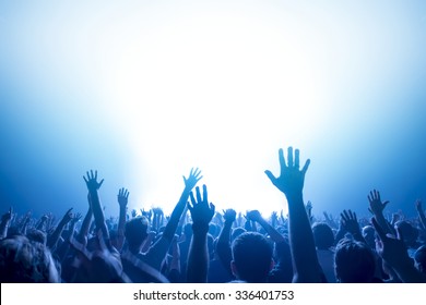 silhouettes of concert crowd in front of bright stage lights - Shutterstock ID 336401753