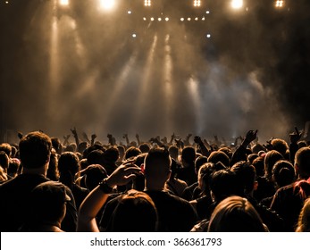 silhouettes of concert crowd in front of bright stage lights - Shutterstock ID 366361793