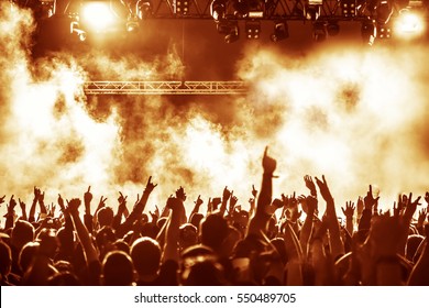 silhouettes of concert crowd in front of bright stage lights - Shutterstock ID 550489705