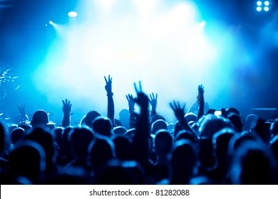 Silhouettes Of Concert Crowd In Front Of Bright Blue Stage Lights