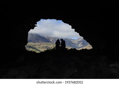 Silhouettes Of A Couple Backlit Inside A Cave In The Ansite Fortress In Gran Canaria, Spain