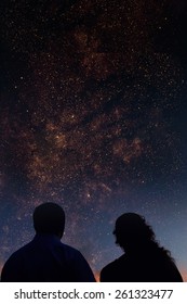 Silhouettes Of Couple Looking At Stars. Starry Night Sky With Colorful Galaxies, Astronomical Background With Place For Your Text.Elements Of This Image Furnished By NASA.