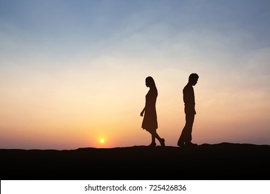 Silhouettes of couple man and woman  broken heart. In nature sunset. Love concept.