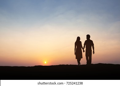 Silhouettes of couple man and woman In Nature sunset. Couple love concept.