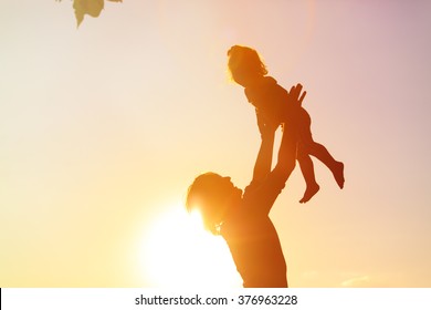 siluetas de padre e hija jugando al atardecer
