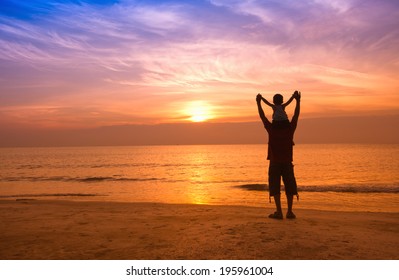 silhouettes of father and son on sunrise sea background,family concept silhouettes of father and son on sunrise sea background,family concept
