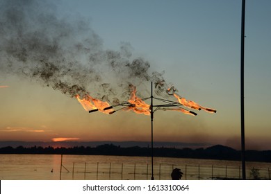 silhouettes of fire eaters at lake during sunset - Powered by Shutterstock