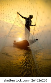Silhouettes fisherman throwing fishing nets during sunset, Thailand.