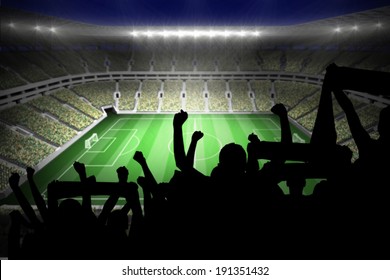 Silhouettes of football supporters against large football stadium with lights - Shutterstock ID 191351432