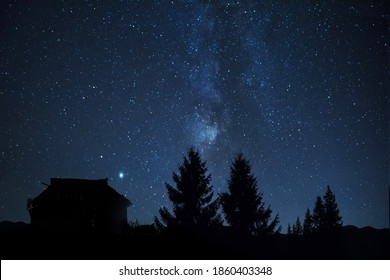 Silhouettes of a huge fir tree and an old vintage house. against the background of the starry sky and the Milky Way. Night photo. Fabulous mystical photo. - Powered by Shutterstock