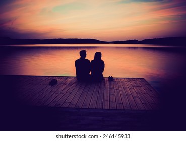 Silhouettes Of Hugging Couple Against The Sunset Sky. Vintage Photo.