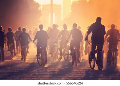 Silhouettes Of Many People On Bicycles On The Sunset In The City Park 