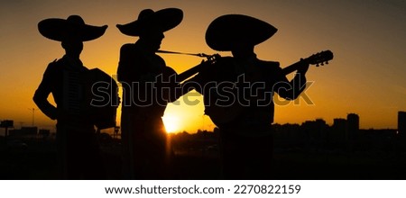 Silhouettes of a mexican musicians mariachi band on a background of city panorama.
