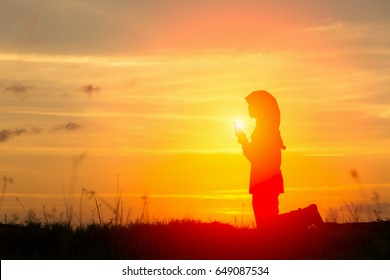 Silhouettes Muslim prayer,the light of faith, hope, faith, supplication,Muslim girl praying faith in Allah God of Islam supremely.