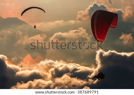 Silhouettes of para glider over the clouds