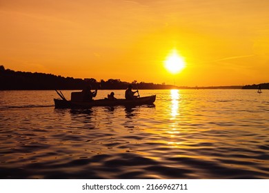 Silhouettes of people in boat at sunset. Family from mom, dad and child ride boat on river. Small family trip, members spends time together, has rest and relax. - Powered by Shutterstock