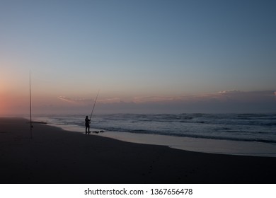 Silhouettes Of People Fishing On Morgan Bay Beach At Sunset, Wild Coast, Eastern Cape, South Africa.