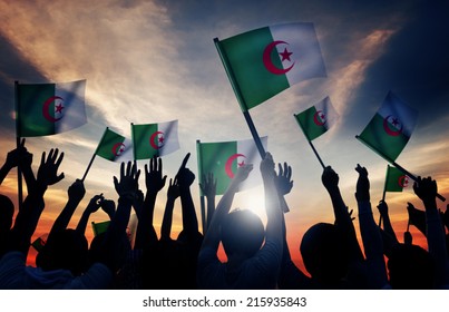 Silhouettes Of People Holding Flag Of Algeria