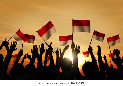 Silhouettes Of People Holding The Flag Of Indonesia Concept