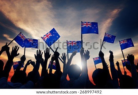 Silhouettes of People Holding Flag of New Zealand