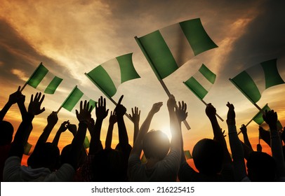 Silhouettes Of People Holding Flag Of Nigeria